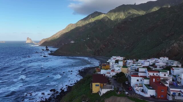 View of the village of Almaciga and the ocean coast and the rugged terrain of Anaga Rural Park. Canary Islands. Tenerife. Aerial video. 4K 50fps.