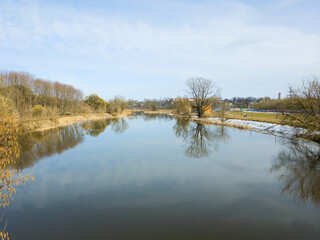 Fototapeta premium Tranquil River With Tree Reflections On Clear Spring Day