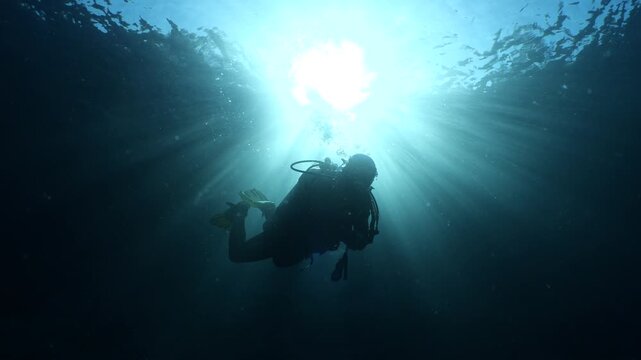 silhouette  scuba diver sun beam shine rays underwater ,diver relaxing blue ocean scenery of people