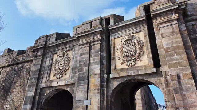 Closer view of the monumental stone arch city gate Porte Saint-Vincent with two shields in Saint-Malo, Intra-Muros, France