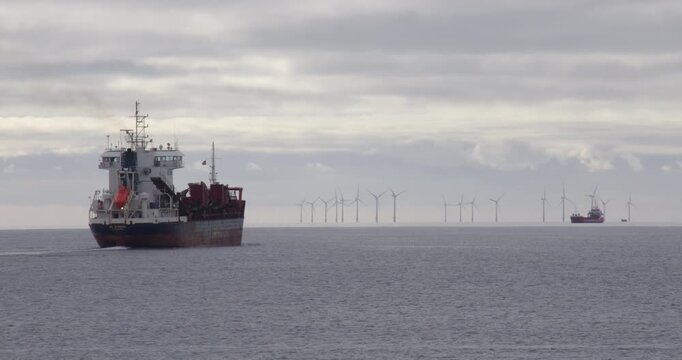 Wide shot of a large commercial ship leaving Shoreham harbour