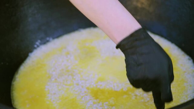 Close Up Female Chef Making Wells in Rice for Pilaf in Large Cauldron