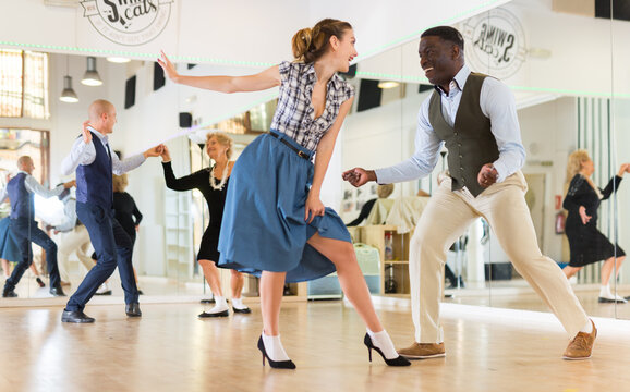 Man and woman performing jazz dance in dancing room