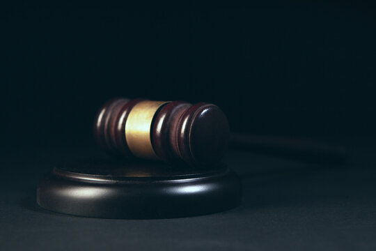 Law theme, mallet of judge, wooden gavel on black background