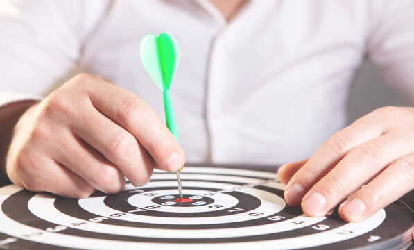 Close-up Of A Businessman's Hand Holding Arrow On Target
