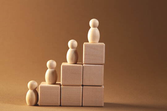 Wooden figures of people on a wooden podium. Business concept.