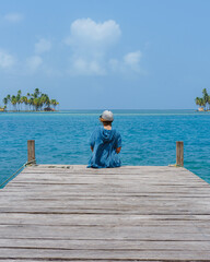 Fototapeta premium Woman sitting in a pier during summer vacation 