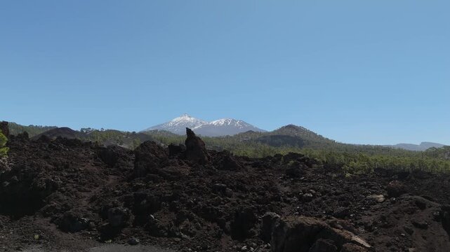 Aerial view from a drone flying over lava fields in the highlands of western Tenerife with Mount Teide in the background. Mirador de los Poleos 