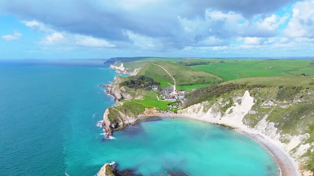 Ascending aerial shot of Lulworth cove and Dorset jurassic coastline on a sunny day	