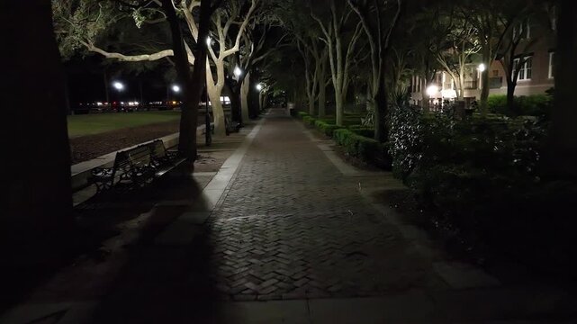 Empty sidewalk at night in Charleston, South Carolina with drone video moving forward.