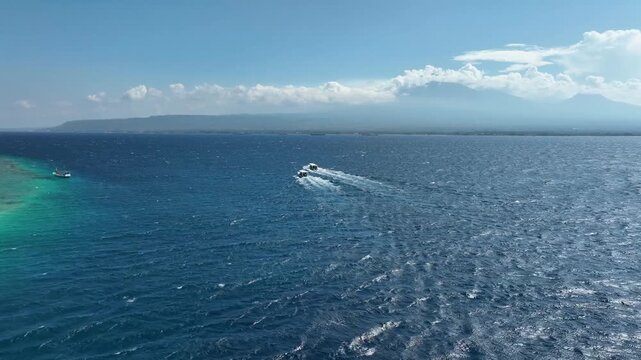 Distant view of Mount Merapi and Ijen with a boat on the sea, peaceful vibe