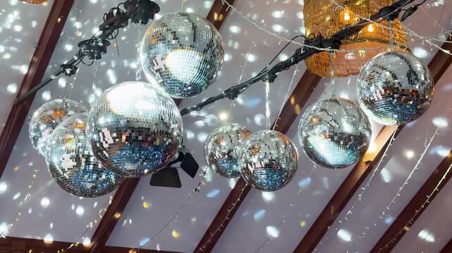 Close-up of a classic silver mirror ball rotating and scattering bright light reflections, creating a nostalgic and energetic party atmosphere.