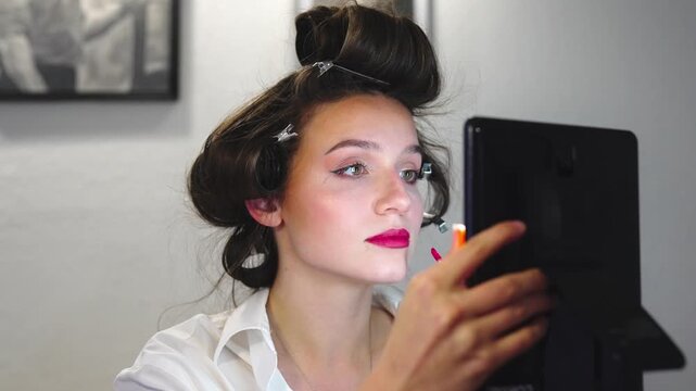 Woman enhancing appearance through makeup and hair styling