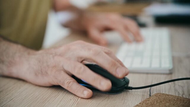 Close-up of hands using computer mouse and keyboard at desk for office work and productivity, 4K