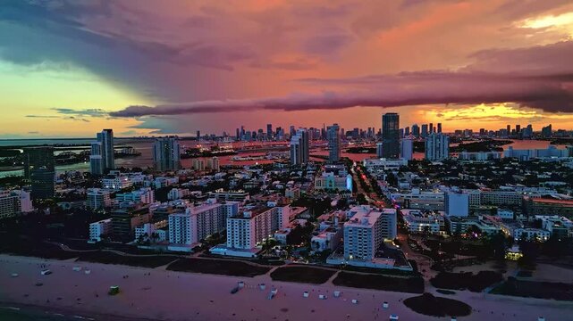 Cinematic wide-angle drone footage of the South Beach coastal skyline and vibrant turquoise waters during a warm Florida golden hour.