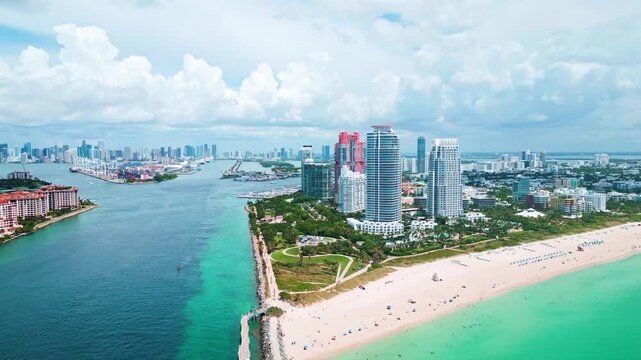 Cinematic aerial drone footage of the iconic South Pointe Park beach, colorful lifeguard towers, and the luxury high-rise skyline of Miami Beach.