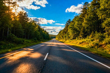 Fototapeta premium Scenic Highway Through Lush Forests at Sunset