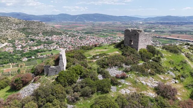 Curved aerial movement over ancient archaeological ruins and surrounding terrain.