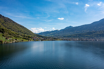 Obraz premium Aerial panorama of Lake Zug - calm blue waters, lakeside villages, rolling green slopes and alpine ridges