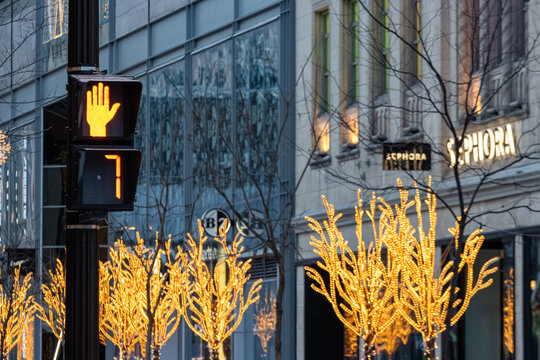Canada, Montreal, 22 December 2025 : Illuminated trees, stop sign, Sephora store, bustling urban street.