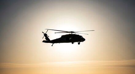 Fototapeta premium Silhouette of military helicopter flying against bright sky at sunset