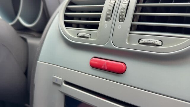 Driver pressing emergency hazard warning button