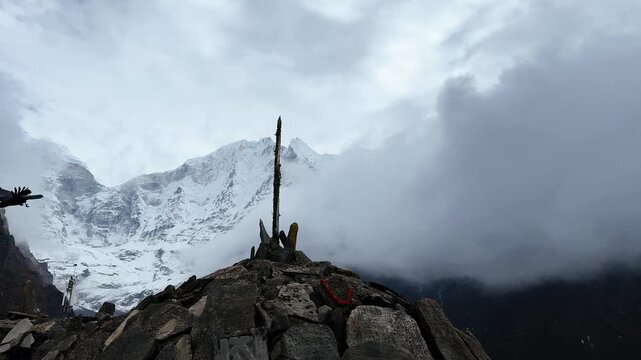 Slow motion of a raven taking off and flying over snowy Himalayan mountains. Dramatic clouds and high peaks create a mystical, cinematic atmosphere in remote alpine wilderness