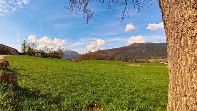 4K Timelapse alpine summer video with moving clouds, a farm, Mount Watzmann and Mount Hochkalter at Aschauerweiher, Berchtesgaden, Bavaria, Germany