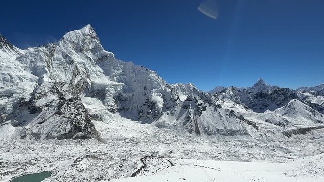 Smooth camera movement over Mount Everest and surrounding Himalayan peaks from Kala Patthar, Nepal. Panoramic view of valley, glacier and Everest Base Camp in clear sunny weather