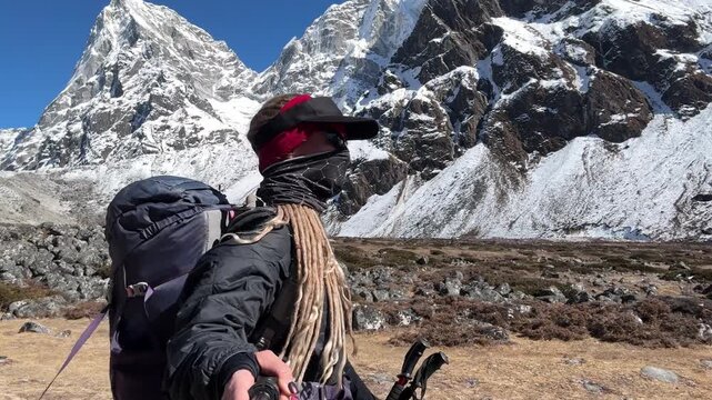 Young woman with dreadlocks hiking in the Himalayas on Everest Base Camp trek, Nepal. Backpacking traveler walking in mountains, adventure, freedom, travel lifestyle, nature