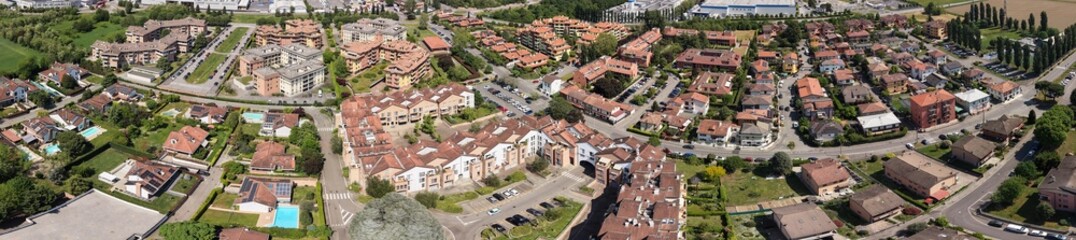 Obraz premium Panoramic View of a Suburban Landscape: An expansive, elevated perspective reveals a well-planned suburban layout, showcasing residential buildings, green spaces, and community infrastructure.