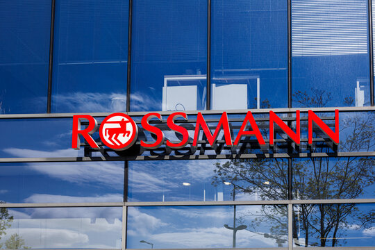 Warsaw, Poland &ndash; April 18, 2026: Rossmann logo on glass office building facade with reflections of sky and trees