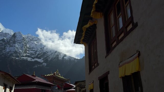 Slow motion monastery window curtains moving in the wind with Himalayan mountain peaks in background at Tengboche Monastery, Nepal. Peaceful spiritual atmosphere, calm, meditation, travel