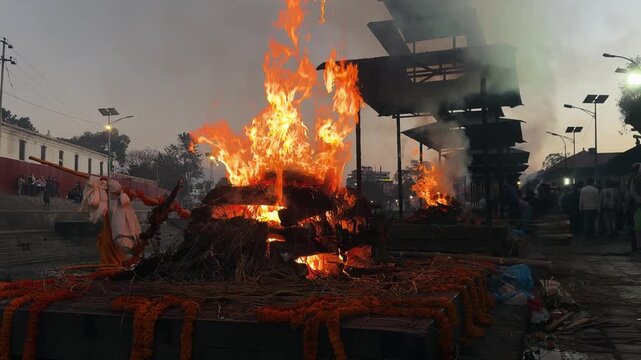 Sacred fire burning at Pashupatinath temple in Kathmandu, Nepal. Spiritual ritual atmosphere with unrecognizable people in background, Hindu culture, meditation, calm, religion, slow motion