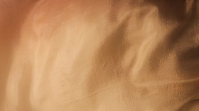 Natural silk fabric waving in the wind. Abstract beige and brown flowing waves background. Real luxury material texture with smooth movements. Soft textile surface in neutral earthy tones.