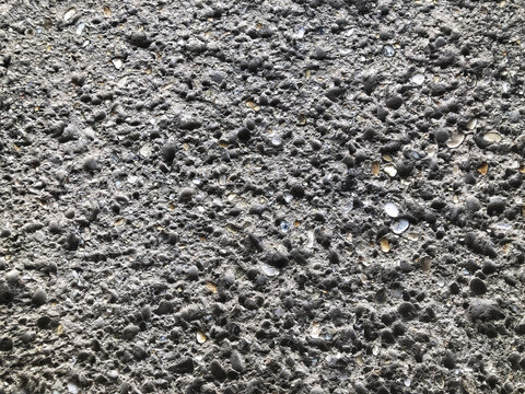 Close-up of a dark textured concrete aggregate wall surface