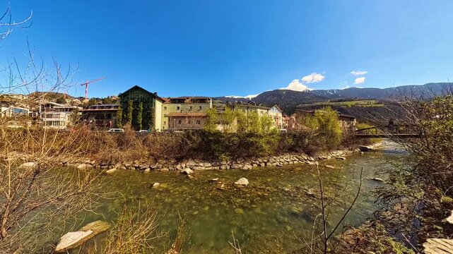 4K Timelapse alpine summer video with moving clouds and reflections in a river at Brixen, Bressanone, Eisacktal valley, South Tyrol, Italy