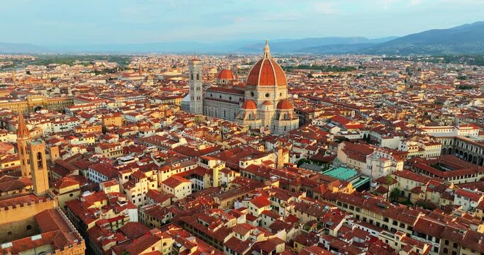 Cinematic aerial perspective Florence Italy city landmarks Cathedral Duomo red tiled roofs pattern mountains background summer travel tourism destination Tuscany panorama.