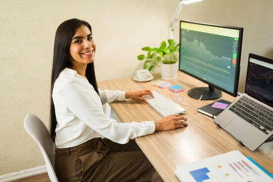 Female investor managing stock market fluctuations from home office, analyzing financial charts and data on multiple screens