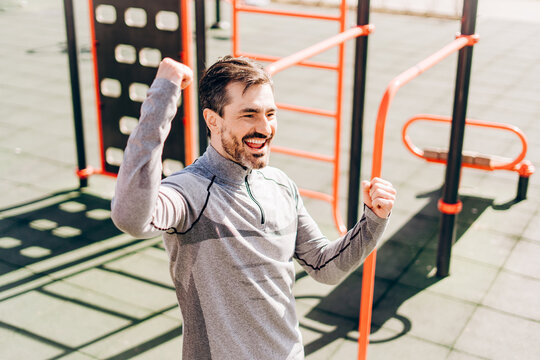 Excited man celebrating success after workout outdoors