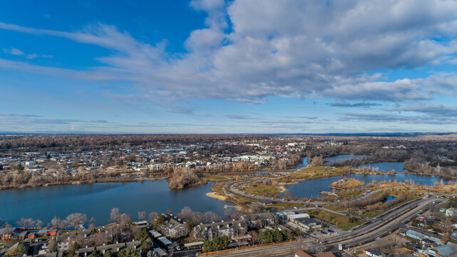 Wide Aerial Panoramic of Suburban City with Multiple Ponds and Water Features Under Dramatic Blue Sky with Clouds