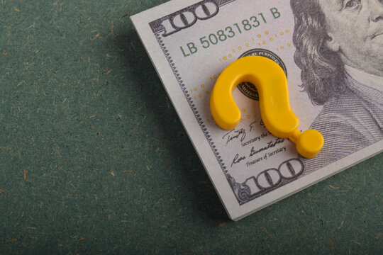Question mark on a US dollar bill, representing financial uncertainty, investment risk, money decisions, and economic questions