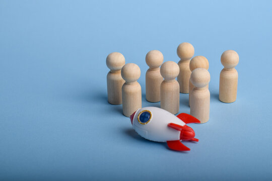 Rocket in front of wooden team figures, representing teamwork, innovation failure, problem solving, collaboration challenges, and business recovery concept.