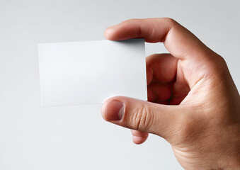 Obraz premium Hand holds blank white card against a light gray background