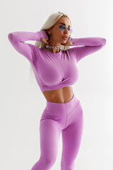 Obraz premium Beautiful woman in leggings on the gray background. Athletic girl