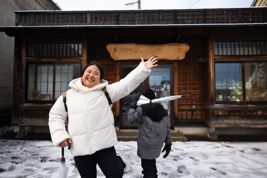 Family travel and Vacation together, Asian mother and son Traveler on Sidewalk with Cityscape Background. street. Boy Enjoying Sunny Winter Day in Picturesque Town. child posture suggests curiosity