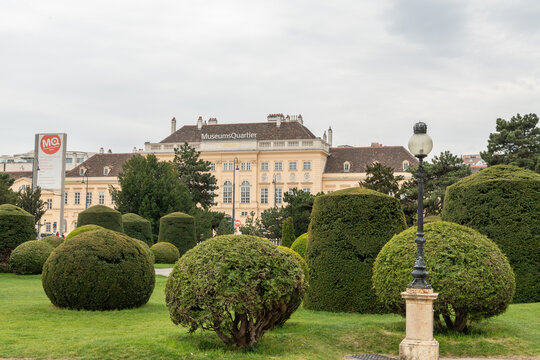 14 April 2026, Vienna, Austria. MuseumsQuartier building behind geometric trimmed bushes in park