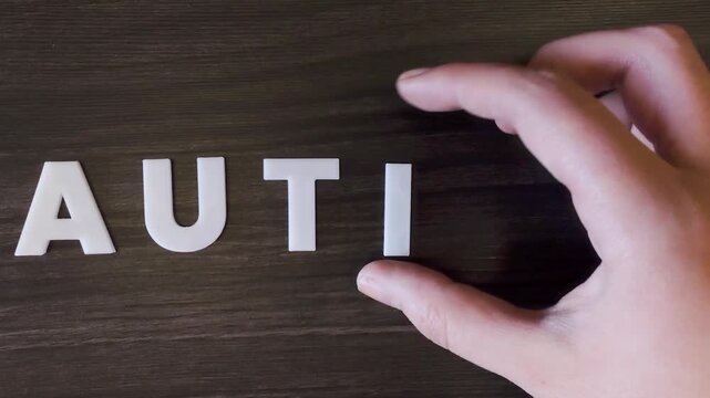 the word autism written on a dark background with white block letters or capital letters (fast version)
