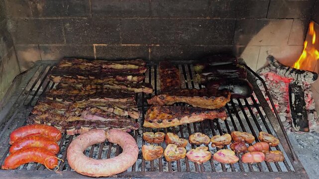 Delicious argentinian asado grilling over hot coals. 4K