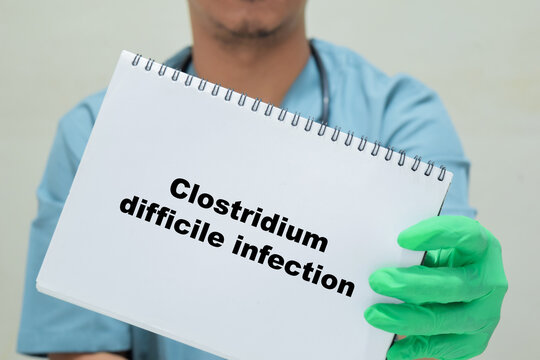 Doctor holds in hands a book with the name of the clostridium difficile infection. Medical concept
